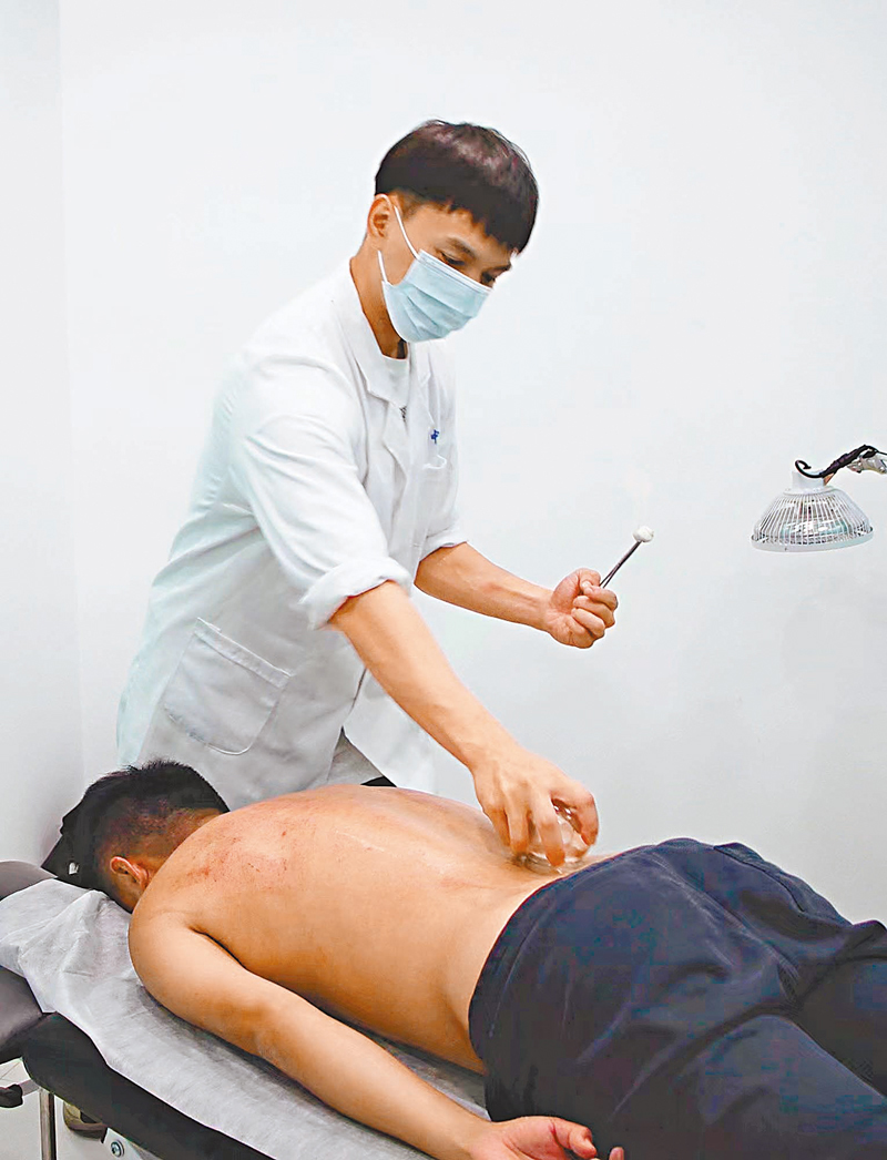 ◆弟弟李赫軒正在為患者拔罐。香港文匯報記者李兵 攝