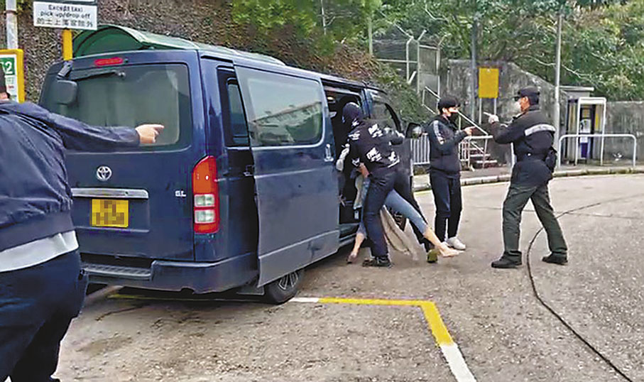 ◆女事主被歹徒抱起推入車廂後，從另一邊門逃出，但被歹徒捉住，她再被強行拉上車，其間有懲教署人員上前阻止。 視頻截圖