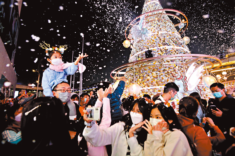 ◆ 漫天飛雪讓市民感受一個白色聖誕，小朋友張開手接觸雪花。 香港文匯報記者北山彥  攝