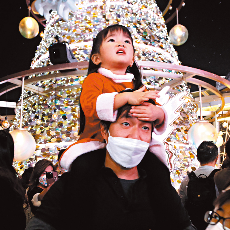 ◆ 小朋友「騎膊馬」，看着漫天「飛雪」，不由得張口驚嘆。香港文匯報記者北山彥  攝