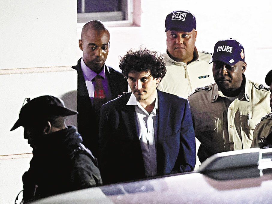 ◆FTX爆煲後，創辦人兼前行政總裁弗里德（中）被捕。 資料圖片