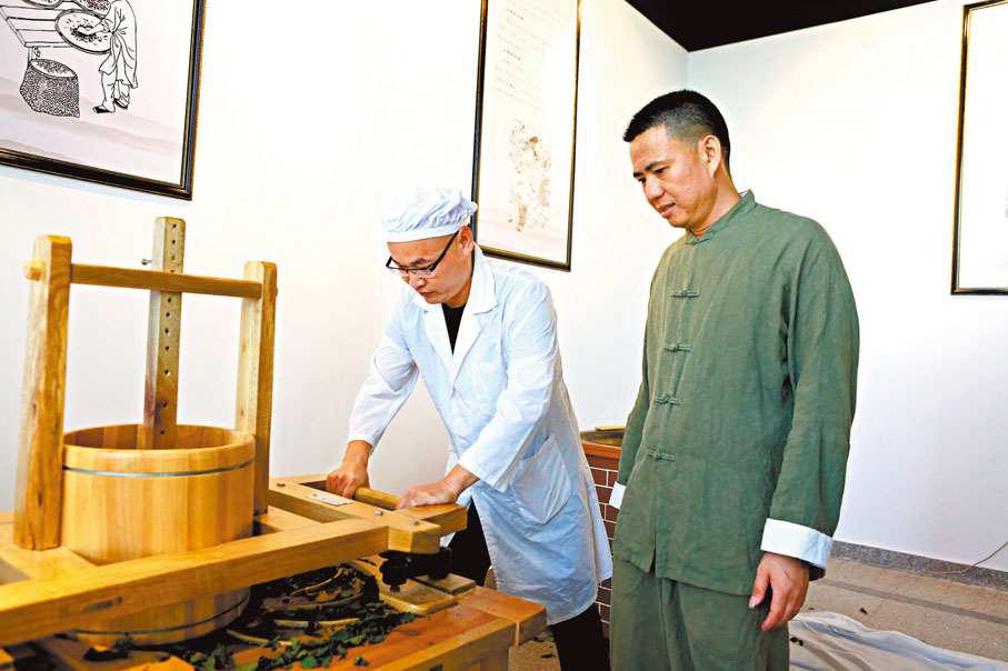 ◆ 李金登（右）在向徒弟傳授製茶技藝。香港文匯報泉州傳真