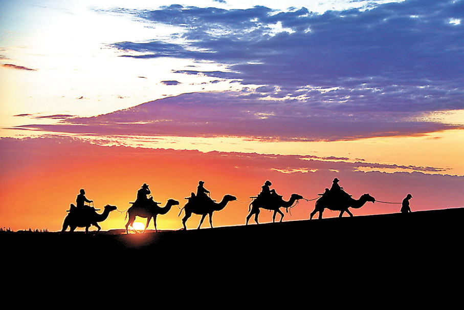 ◆夏日晨曦下，遊客在甘肅省敦煌市鳴沙山月牙泉景區遊覽。