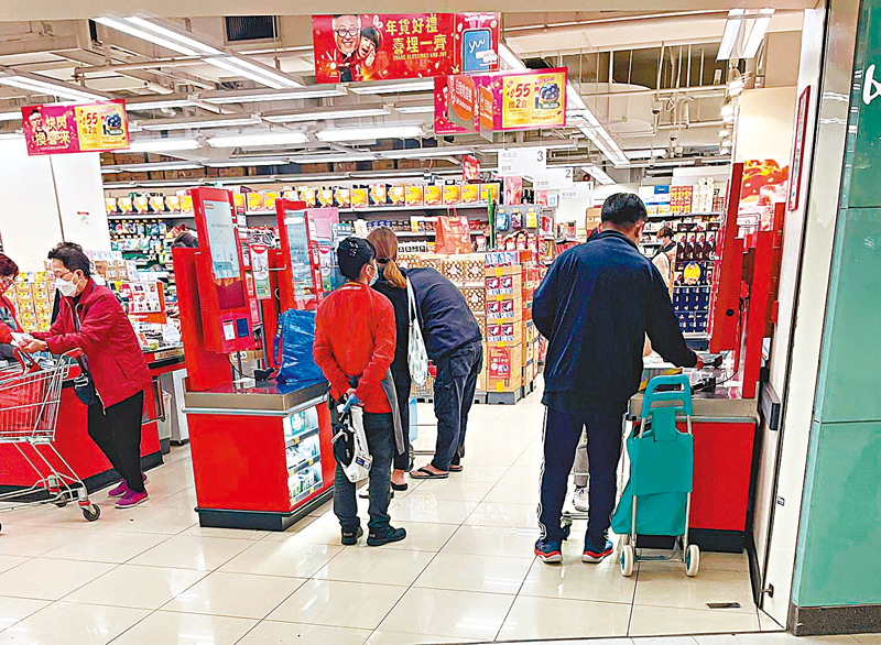 ◆ 超市職員手持膠袋在自助付款區檢視市民使用膠袋情況。香港文匯報記者張弦  攝