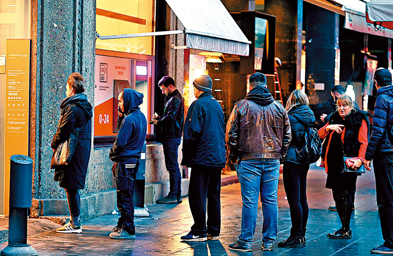 ◆克羅地亞民眾擔心元旦後自動提款機無法運作，排隊等候進入銀行提取現金。 法新社