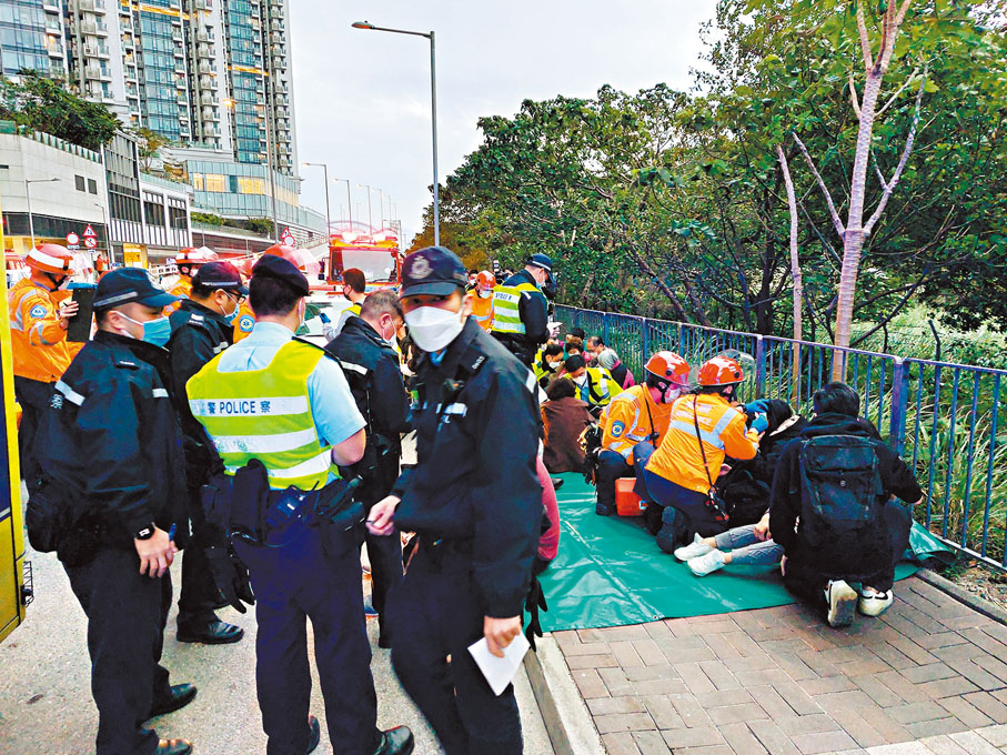 ◆被救出的巴士乘客獲安排坐在路邊檢查傷勢並分流。香港文匯報記者鄺福強  攝