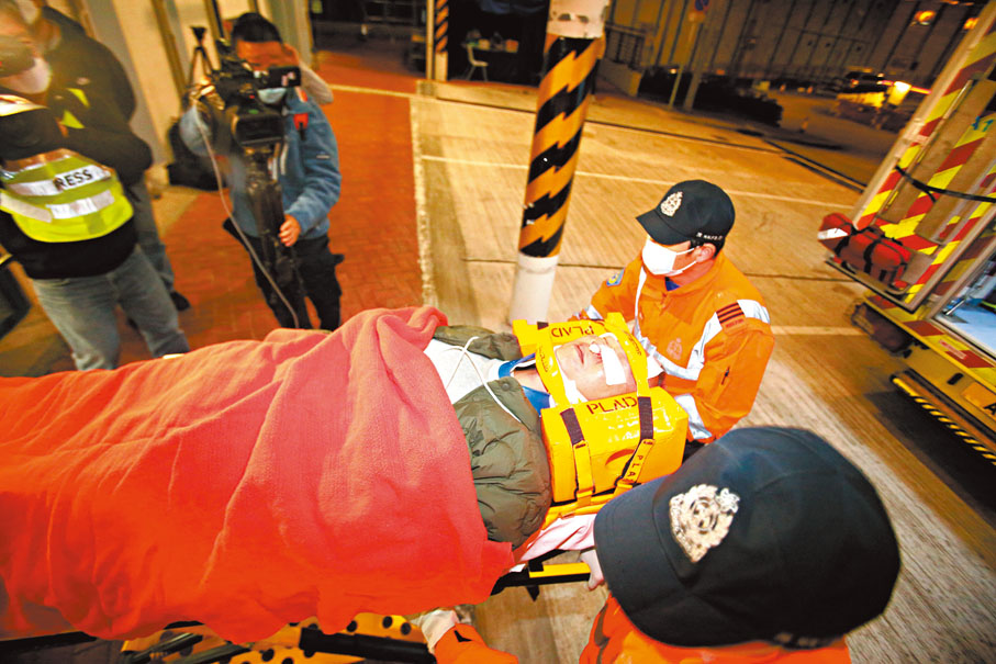 ◆一名頭部受傷的傷者，需要用擔架床送院救治。香港文匯報記者鄺福強  攝