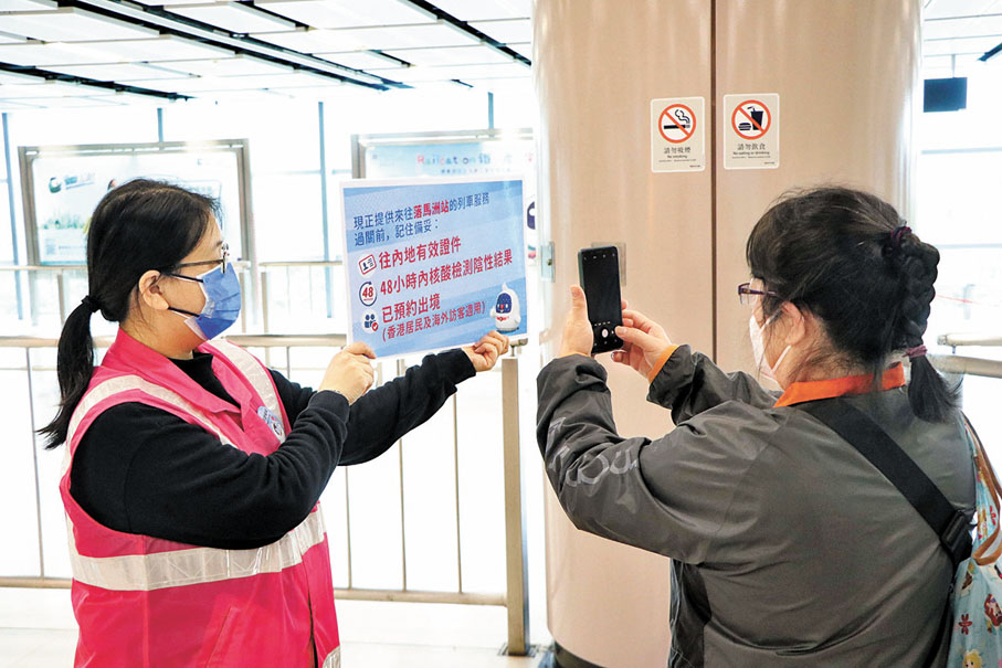 ◆港鐵職員提示出境旅客需帶備的證件、文件。香港文匯報記者北山彥 攝