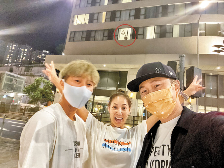 ◆ 2021年大仔（紅圈）返港須接受21天隔離，朱仲賢(右) 與家人不時到酒店樓下隔住玻璃打氣。 受訪者供圖