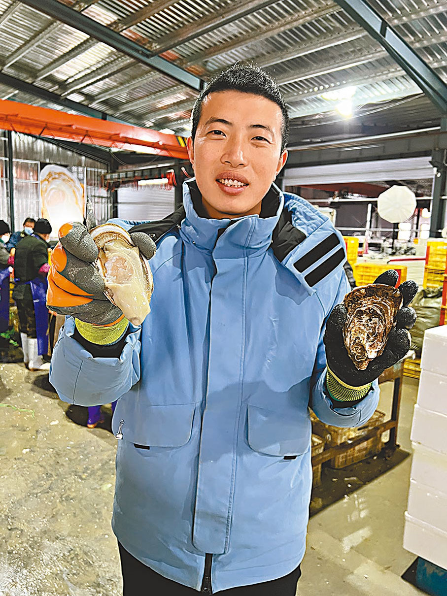 ◆吳東展示自家生蠔，和其手掌一樣大。  香港文匯報深圳傳真