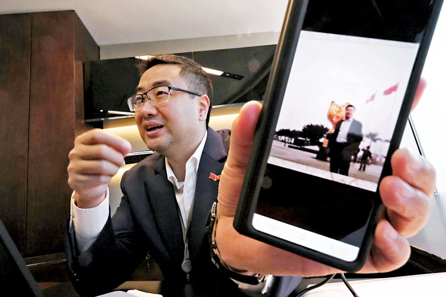 ◆尚海龍展示首次到金紫荊廣場時的「珍藏」照片。香港文匯報記者涂穴  攝