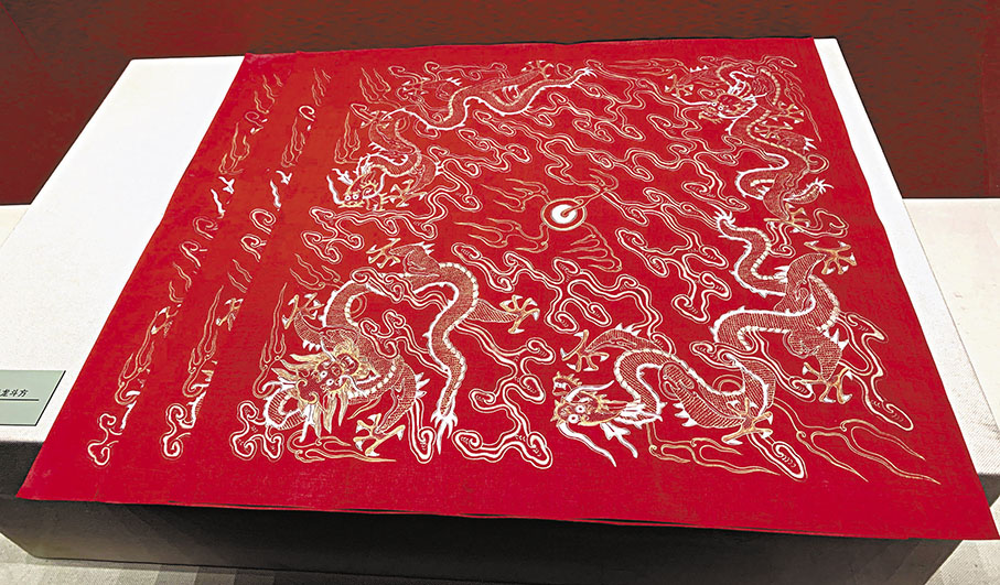 ◆清朱紅絹描金雲龍斗方。這一文物是皇帝在新春賜福時御用的紙，由清宮內務處與江寧織造局共同製作，皇帝督造完成。