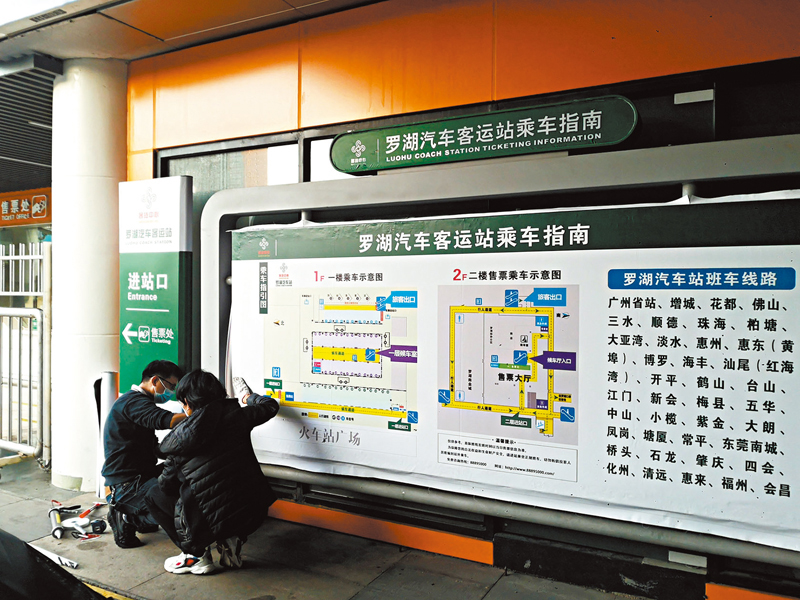 ◆ 羅湖汽車站工作人員正在張貼最新的乘車指南。香港文匯報記者石華  攝