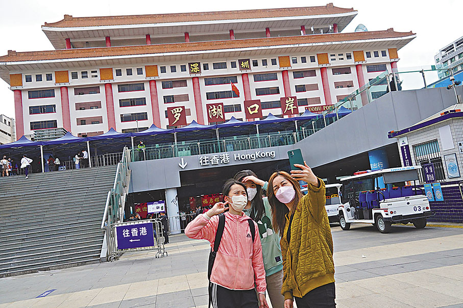 ◆「開心過關」的市民在口岸旁合照。 香港文匯報記者曾興偉 攝