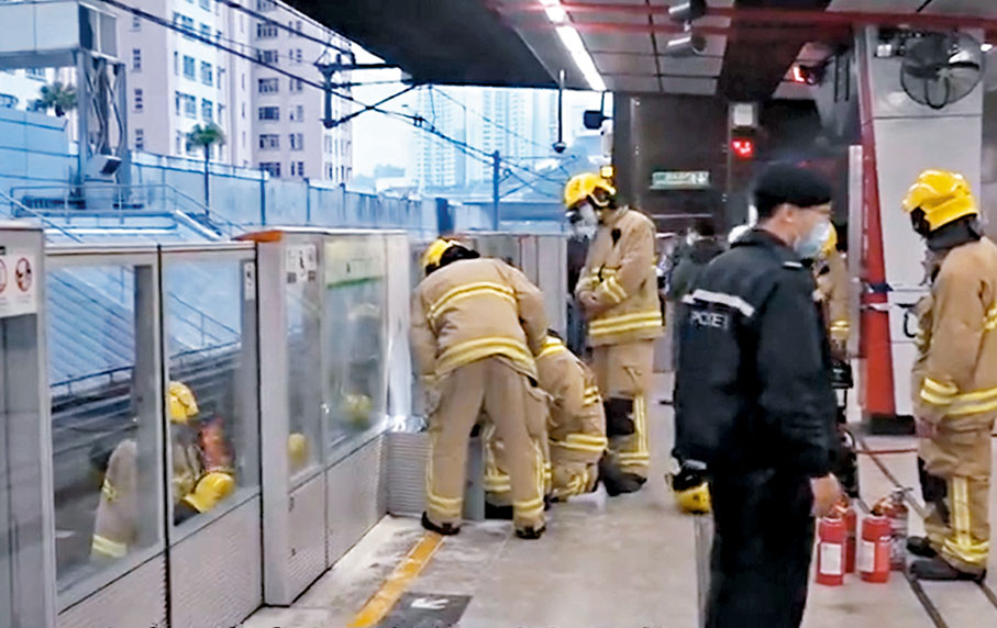 ◆港鐵九龍灣站月台閘門故障冒煙，消防員到場撲救。 有線電視截圖