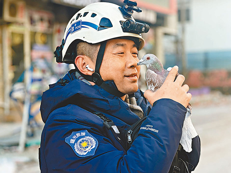 ◆王剛把信鴿捧在手中。廈門曙光救援隊供圖