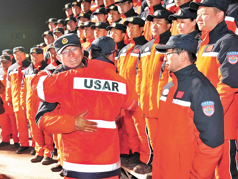◆ 2月17日下午，赴土耳其開展地震救援的中國救援隊和中國香港特區救援隊完成國際救援任務，乘坐國航包機回國。圖為兩隊隊員擁抱。 新華社