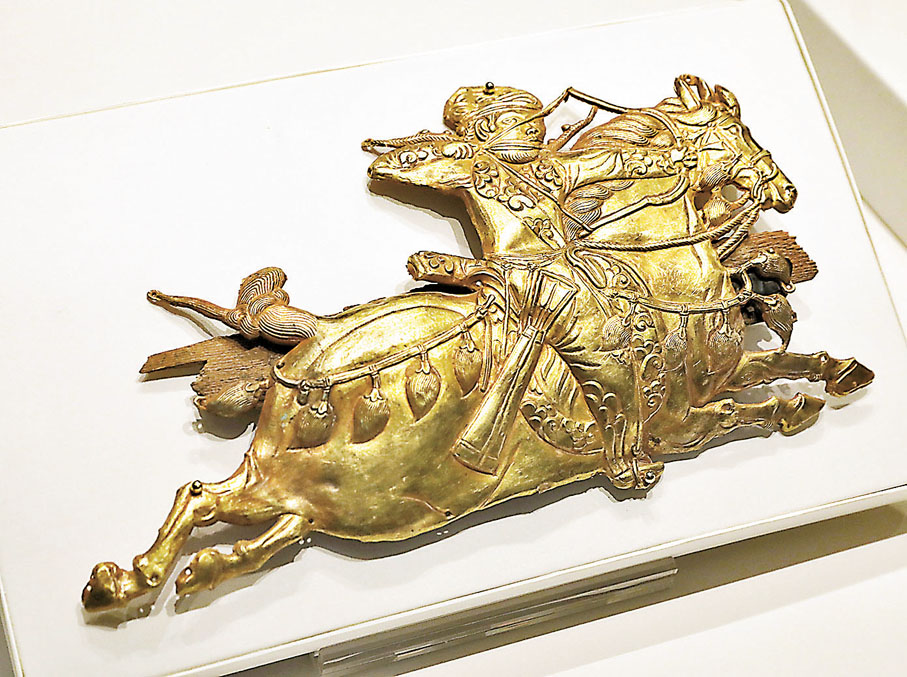 騎射武士形飾牌　存在於吐蕃（公元7至9世紀），駿馬四肢呈水平狀的姿態和騎士髮辮向後飄動的特徵，可追溯至西亞薩珊王朝金銀器上的帝王狩獵圖像