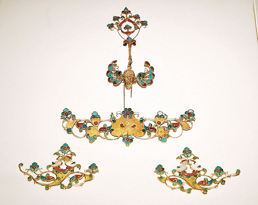 鳳及鴛鴦銜花枝形冠飾　存在於唐朝（公元618至907年），是唐代女性貴族頭飾的一部分，工匠吸納外來裝飾技法在金框中包鑲多種彩色貴重材質，更添雍容華貴之風