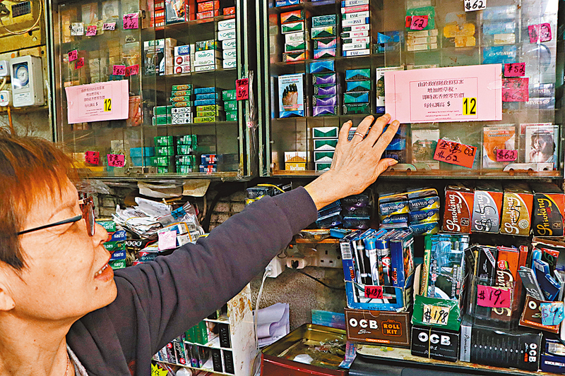 ◆昨日財政預算案宣布加煙草稅後，有士多即時貼出告示，提醒顧客每包香煙加價12元。香港文匯報記者北山彥  攝