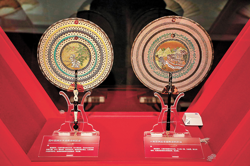 ◆清花葉圖綢面草編髹漆柄團扇（左）和清水榭圖綢面草編髹漆柄團扇（右）。