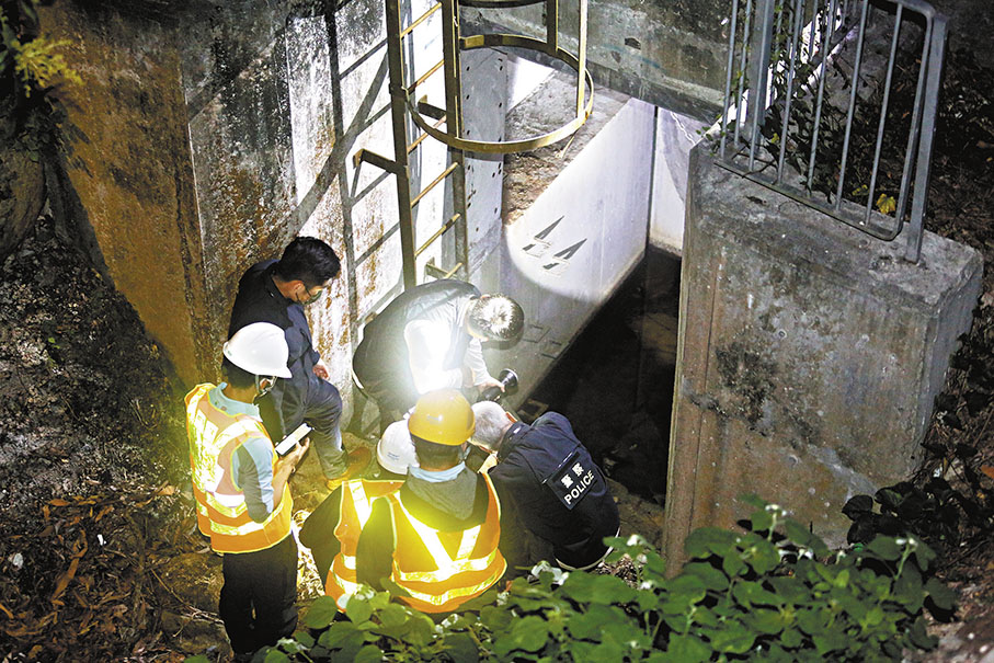 ◆探員在渠務工人協助下到肢解烹屍村屋附近的沙井查看有否人體殘肢。 香港文匯報記者鄺福強 攝