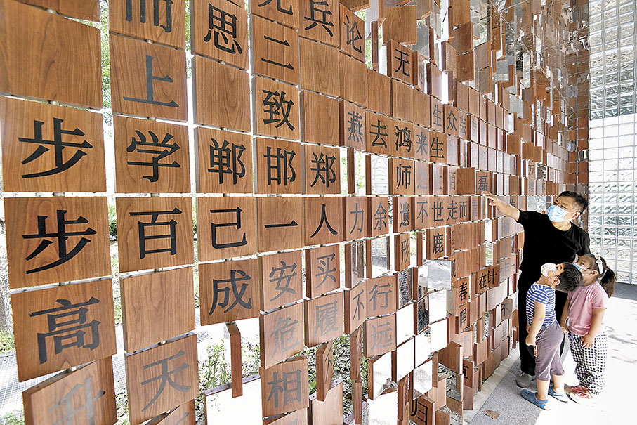◆ 市民在河北省邯鄲市復興區福興園「成語牆」前玩成語遊戲。