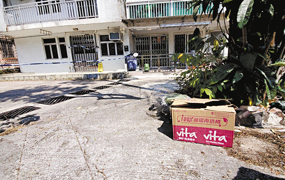 ◆有市民在發生肢解烹屍案的村屋外空地樹下放置紙箱及鮮花悼念死者。