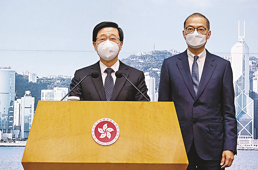 ◆李家超昨日於行政會議前會見傳媒宣布全面取消口罩令。右為盧寵茂。 香港文匯報記者涂穴  攝