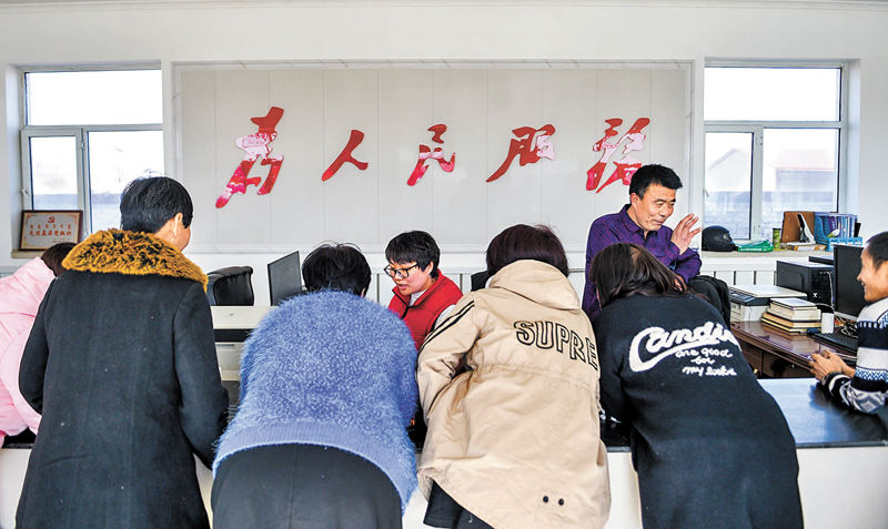 ◆基層幹部正在幫助群眾解決問題。 資料圖片