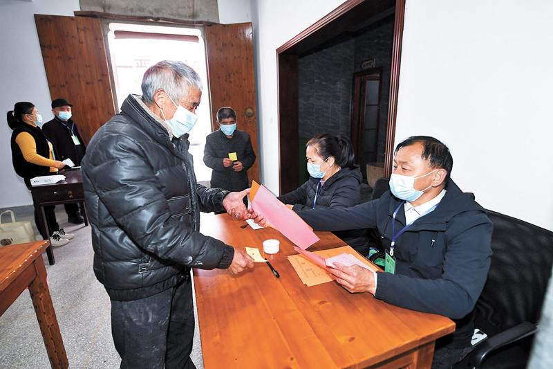 ◆2021年12月14日，村民在浙江省杭州市臨安區湍口鎮迎豐村的基層投票點領取選票參加基層人大換屆選舉投票。 資料圖片