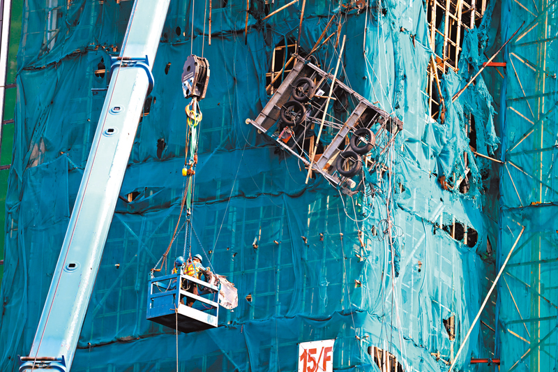 ◆承建商用大型吊臂機協助將傾側的吊船扶正。 香港文匯報記者劉友光  攝