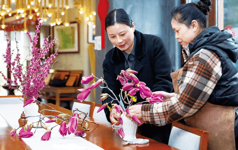◆ 陶勳花手把手教村民插花。