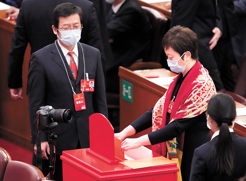 ◆3月10日，十四屆全國人大一次會議在北京人民大會堂舉行第三次全體會議。這是代表在投票。新華社