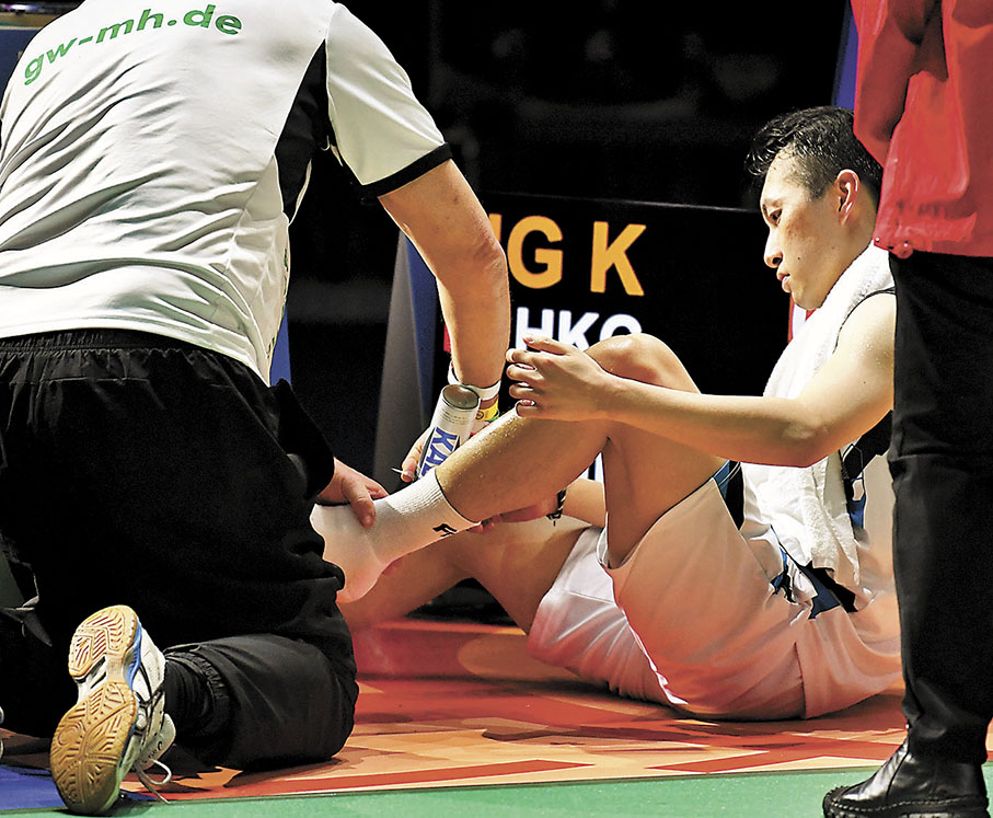 ◆伍家朗在比賽中腿部受傷，需接受駐場醫生治療。 新華社