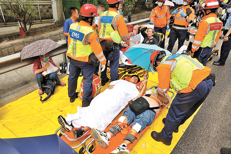 ◆救護員將傷勢較嚴重的傷者安置在一起等候送院。 香港文匯報記者劉友光  攝