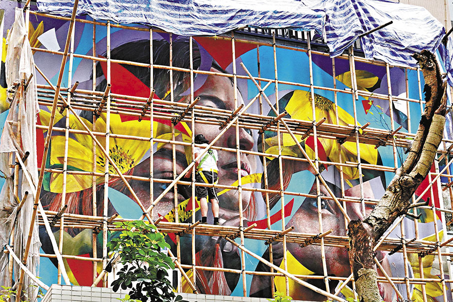 ◆Kogaone喜歡用人的面孔作為題材，他正在棚架上完善自己的作品。