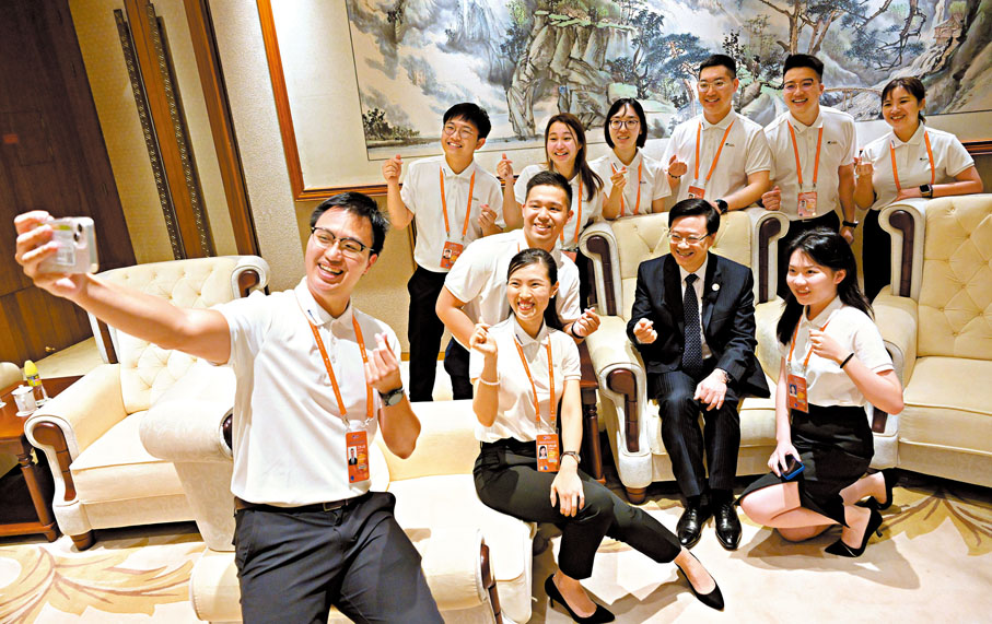 ◆ 李家超（前排右二）在海南出席博鰲亞洲論壇2023年年會港澳青年志願者證書頒發儀式，其間與志願者合照。