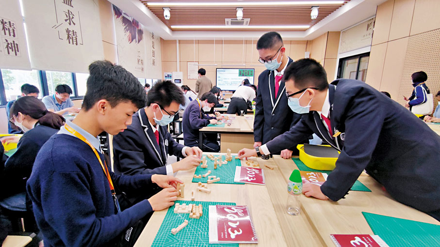 ◆ 首個高中公民與社會發展科學生內地考察團昨日到訪廣州市執信中學。圖為港穗學生一起參與木工課。