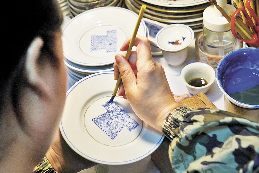 ◆繪工用枕箱托住雙手，一隻手握住毛筆，另一隻手拿着瓷碟，猶如唱片機上的唱針。