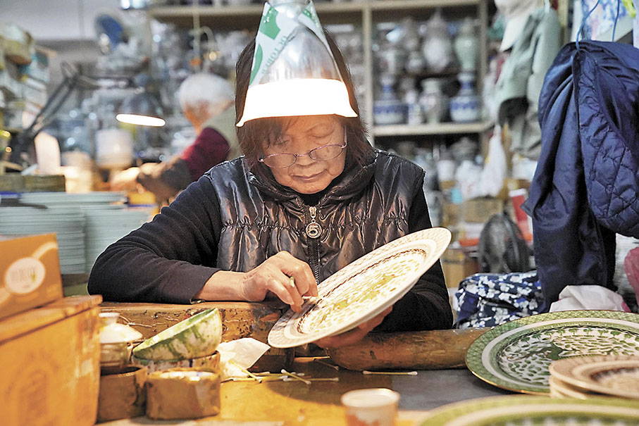 ◆廣彩繪工在製作彩瓷。