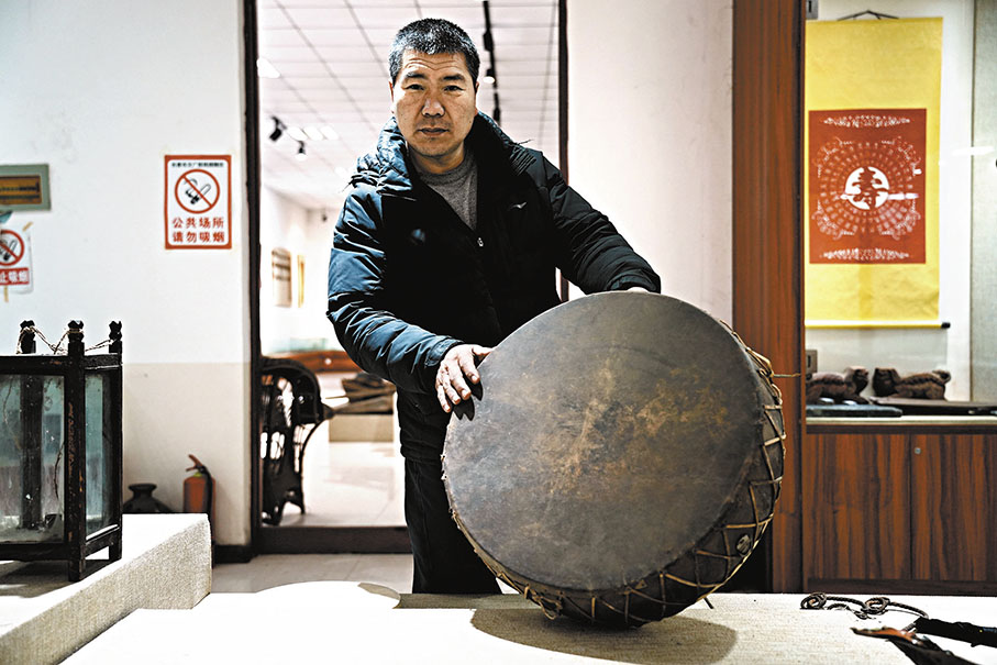 ◆關長寶展示滿族先民祭祀所用的、有300年歷史的烏拉神鼓，該鼓至今依舊能夠敲響。