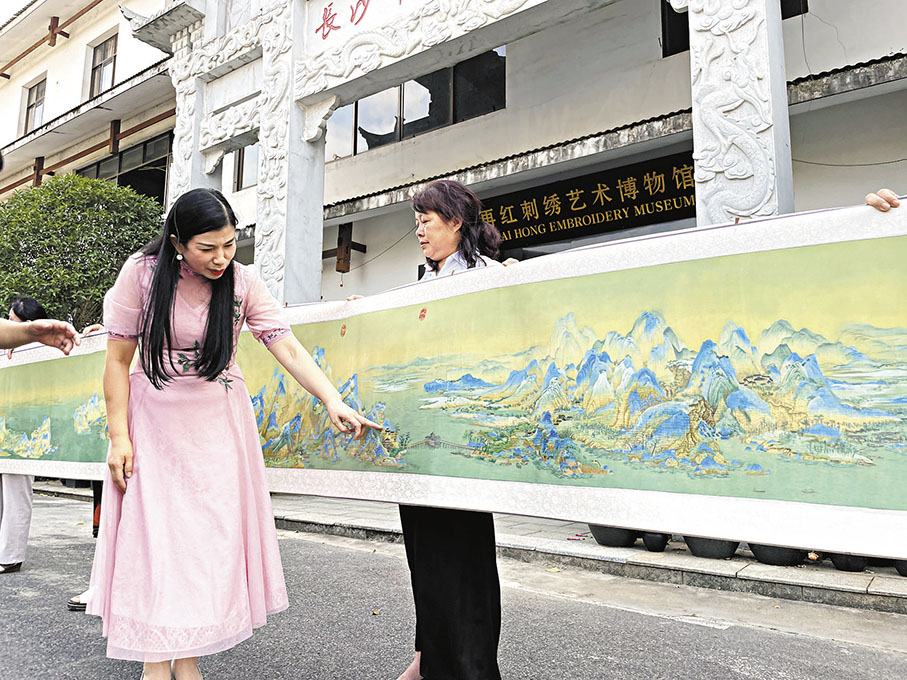 ◆江再紅在介紹湘繡作品《千里江山圖》。 姚進  攝