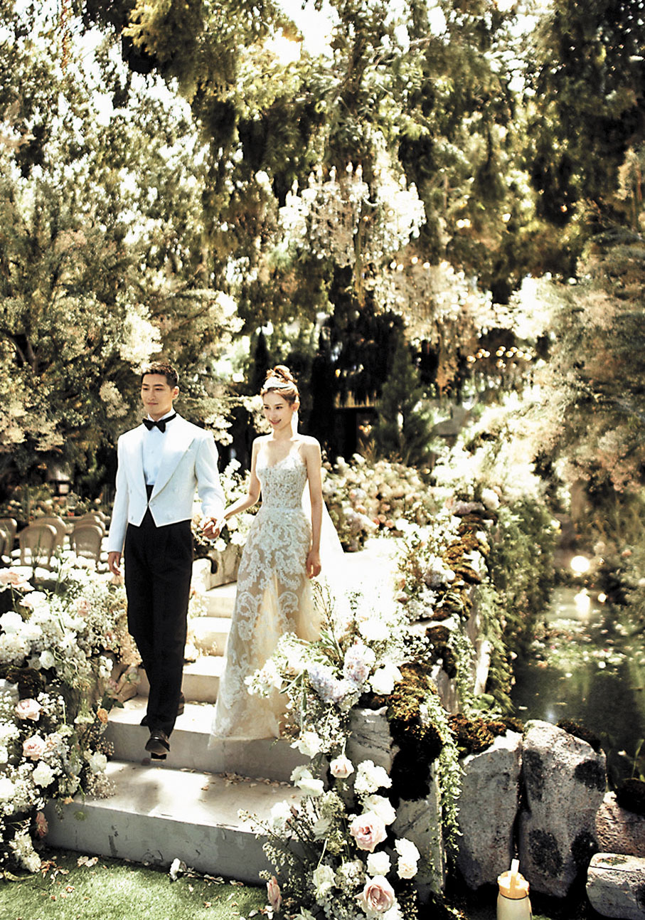 ◆ 竇驍牽身穿一襲白色拖尾婚紗的超蓮，俊男靚女十分養眼。