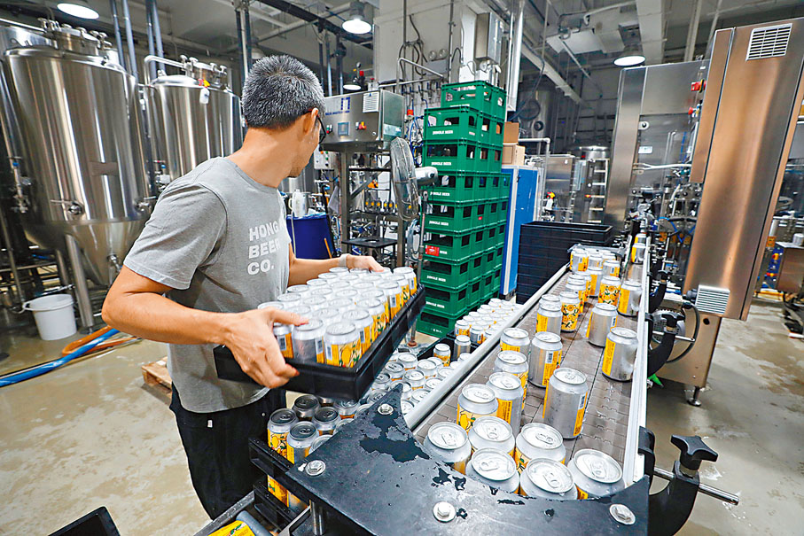 ◆工作人員做最後品質檢查後，便把啤酒入箱推出市場。香港文匯報記者郭木又  攝