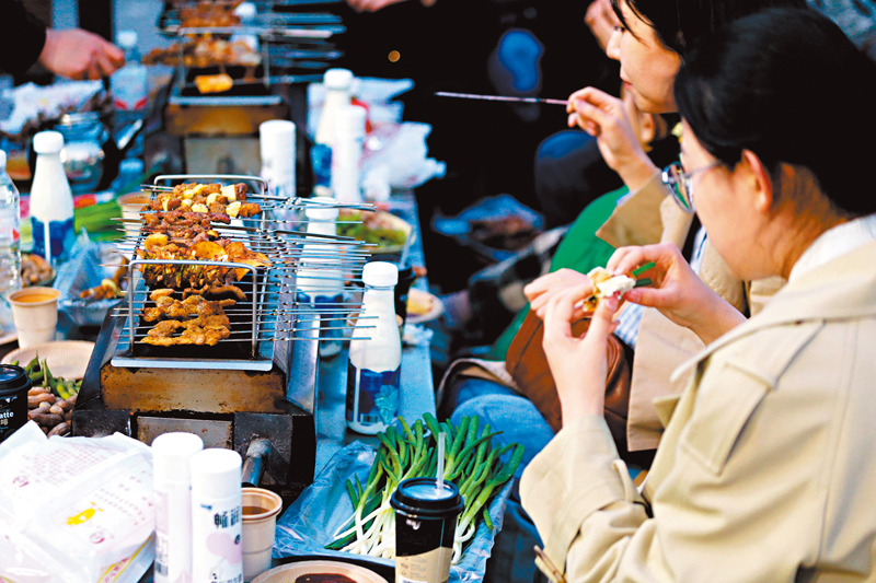 ◆3月31日，山東淄博，食客正在享用燒烤。近來，淄博燒烤在各大社交平台火爆出圈，「大學生組團到淄博吃燒烤」等話題頻頻登上熱搜榜首。 中新社