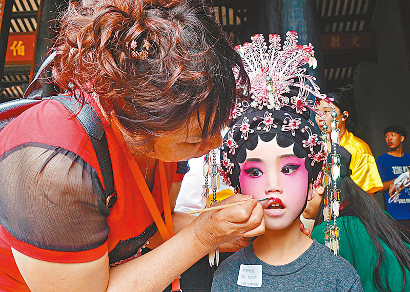 ◆飄色巡遊前，擔任「色仔」「色女」的小演員在上妝中。