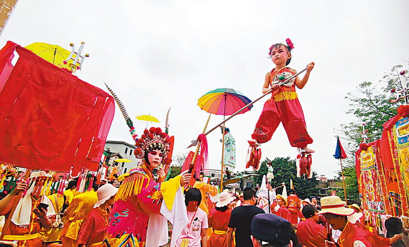 ◆身穿紅肚兜、腳踩風火輪，以哪吒造型亮相的「色仔」小朋友高高「懸」在空中，手握的長槍正與另一位小朋友的劍短兵相接。