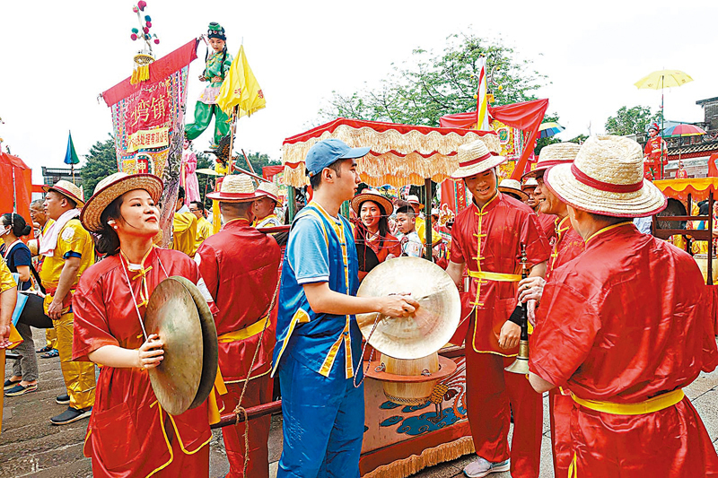 ◆飄色巡遊隊伍中，還有身穿紅衣裳的樂隊隊伍，邊巡遊邊演奏着八音鑼鼓、嗩吶，熱熱鬧鬧。