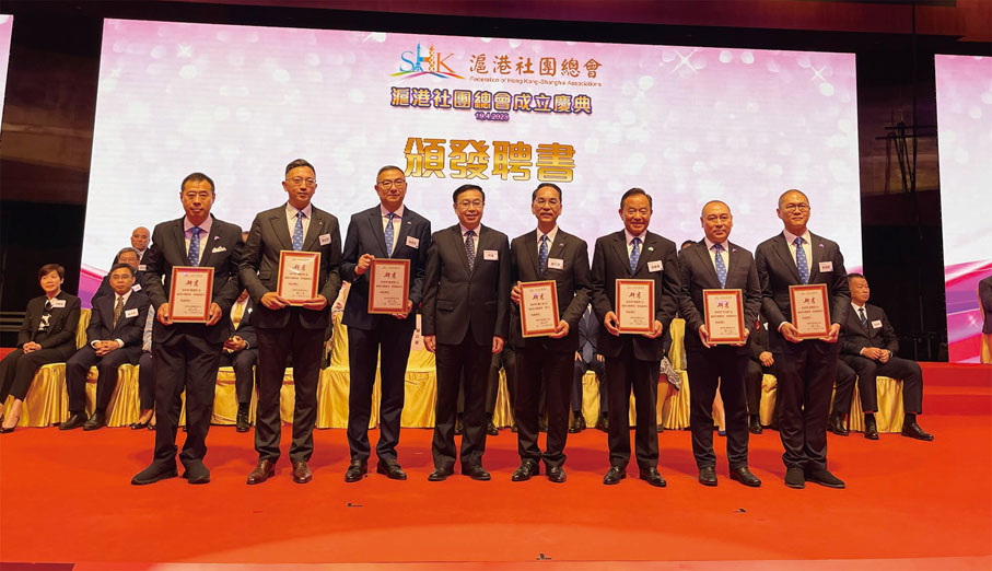 ◆何靖（左四）向滬港社團總會執委會委員頒發聘書。